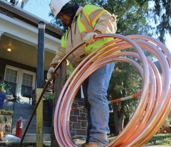 Photo of a worker installing copper pipe