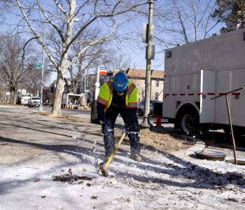 DC Water worker breaking up frozen ice on sidewalk