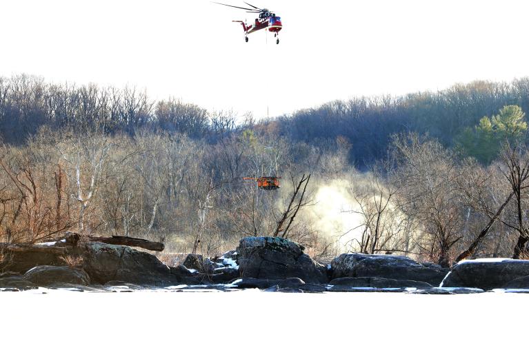 Helicopter carrying drill rig equipment to boring locations in the Potomac River