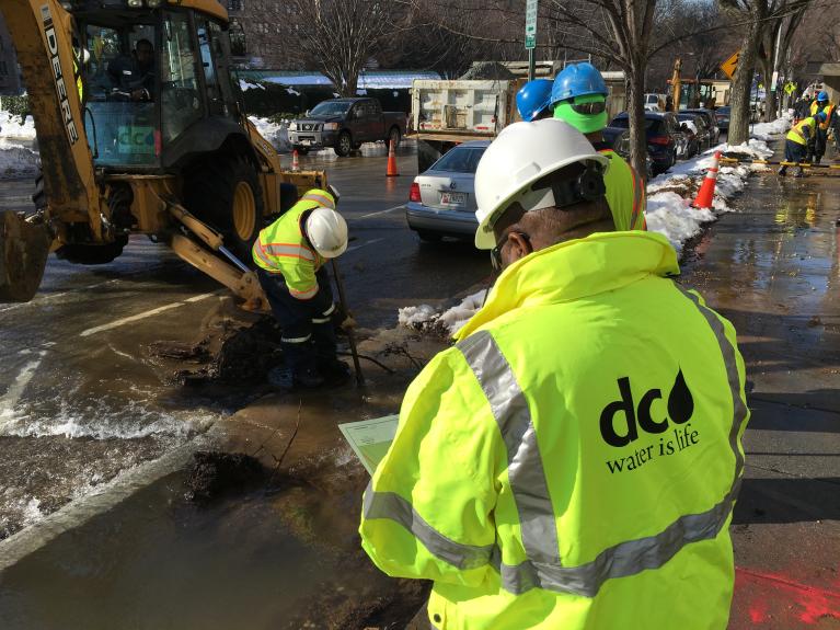 Workers fixing a water main break during the winter