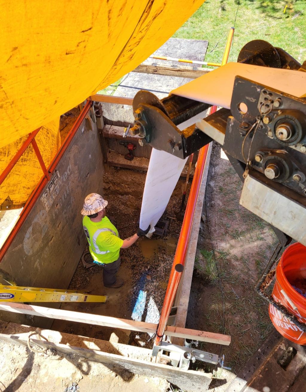 Worker in pit, rehabbing water main