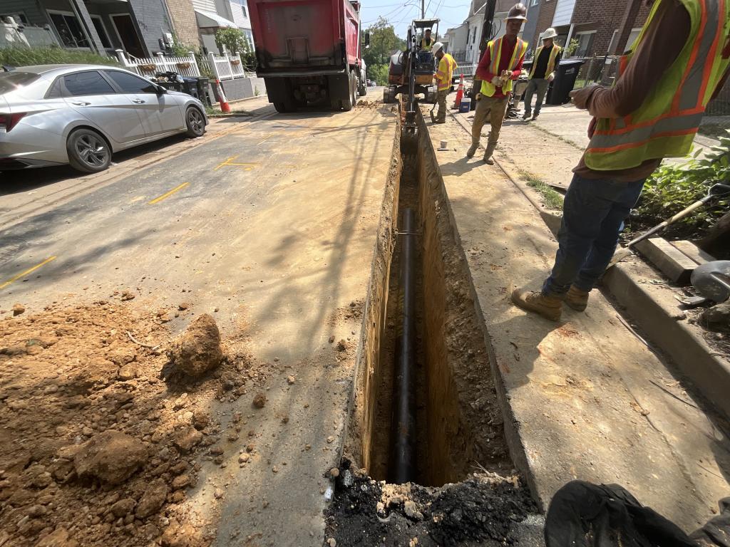 Workers laying replacement pipe.