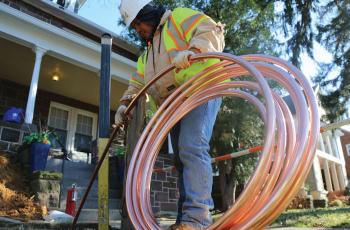 Photo of a worker installing copper pipe