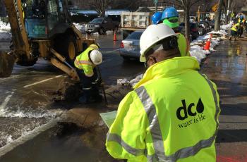 Workers fixing a water main break during the winter