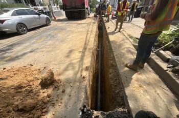 Workers laying replacement pipe.